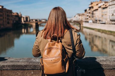 Kadınlar Floransa 'daki ünlü Eski Köprü' de güzel manzaranın tadını çıkarırlar. İtalyan simgelerini ziyaret eden bir kadın gezgin. Seyahat, turizm ve tatil kavramı