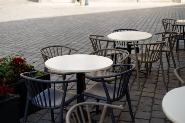 Açık sokak kafe masaları servis için hazır. Sabah vakti masa ve sandalyeli modern boş kafe terası..