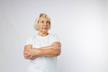 Güzel, son sınıf sarışın kadın gülümsüyor ve beyaz arka plandan kameraya bakıyor. İnsani duygular, yüz ifadesi kavramı