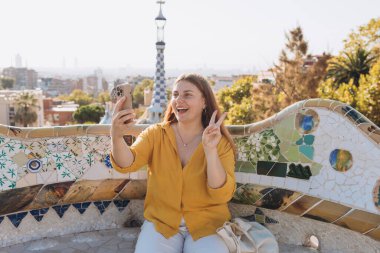 Gaudi Bahçesi, İspanya, Barselona 'da güzel bir kadın. Genç gezgin kadın dışarıda selfie çekiyor. Seyahat, turizm ve tatil kavramı