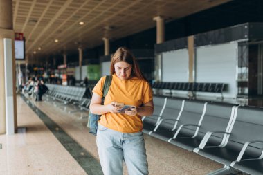 Happy Kafkasyalı Kadın, Uçuş Kapıları 'nda bekliyor. Uçağa binmek için, Mobil Akıllı Telefon kullanıyor. 30 'lu yaşlardaki kadın İnternet' te Yolculuk Hedefini Denetliyor, seyahat kavramı