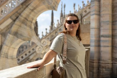 Milano Katedrali Duomo di Milano 'nun çatısında poz veren 30' lu yaşlardaki güzel kadın. Yazın Avrupa 'yı geziyorum. Çekici sarışın kadın şehri keşfediyor. En iyi turistik yer.