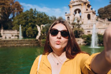 Genç bayan turist Barselona 'daki Ciutadella Parkı' nı ziyaret ediyor. Genç gezgin kadın dışarıda selfie çekiyor. Seyahat, turizm ve tatil kavramı. Teknoloji kavramı kullan