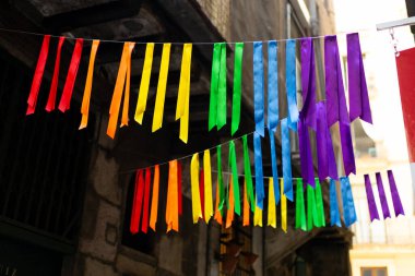 Kentsel arkaplanda renkli gökkuşağı bayrakları var. Kutlama partisi, bayram festivali, festival dekorasyonları..
