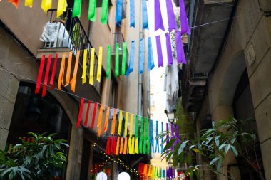 Kentsel arkaplanda renkli gökkuşağı bayrakları var. Kutlama partisi, bayram festivali, festival dekorasyonları..