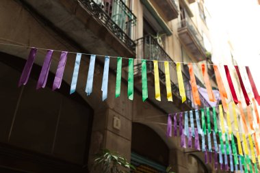 Kentsel arkaplanda renkli gökkuşağı bayrakları var. Kutlama partisi, bayram festivali, festival dekorasyonları..