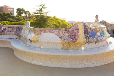 Serpent bench made of mosaic tiles in Park Guell in Barcelona. Concept of travel, tourism and vacation clipart