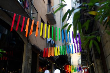 Kentsel arkaplanda renkli gökkuşağı bayrakları var. Kutlama partisi, bayram festivali, festival dekorasyonları..