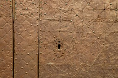 Eski paslı kapı kilidi kapanıyor. Eski kapıda bir anahtar deliği