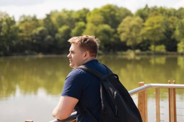Ahşap iskelede duran üzgün adam. Yaşamı düşünüyorum. Güneşli bir sabahta huzurlu bir atmosfer. Doğada yalnız zaman geçirmek.