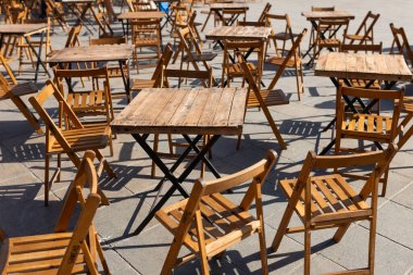 Açık sokak kafe masaları servis için hazır. Sabah saatlerinde masa ve plastik sandalyeli boş bir kafe. Yiyecek konsepti