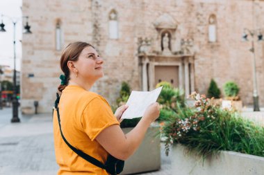 Genç, güzel, 30 'lu yaşlarda İspanyol bir kadın. Şehir haritasına bakıyor. Eski bir kasaba. Çekici genç bayan turist yeni şehri keşfediyor. Avrupa seyahati, yüksek kaliteli fotoğraf