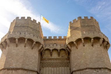 Valencia Topluluğu bayrağı rüzgarda dalgalanıyor. Torres de Quart, Valencia 'da ortaçağ binası.