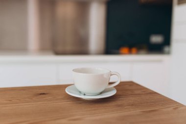 Boş seramik kupa, bulanık mutfak arka planlı ürün görüntüsü