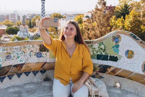 Gaudi Bahçesi, İspanya, Barselona 'da güzel bir kadın. Genç gezgin kadın dışarıda selfie çekiyor. Seyahat, turizm ve tatil kavramı