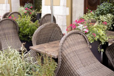 Meydandaki bir kafede, terasta mobilyalar. Şehrin içi çok güzel ve çiçekli.