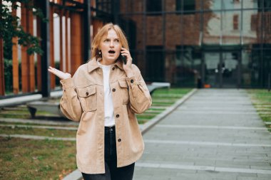 Angry woman on cell phone walking outside building. Frustrated woman talking on phone. Summer time. Negative people emotion clipart