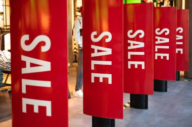 Mağazada kırmızı satış işaretleri var. Mevsimlik indirim teklifi. Kara Cuma ve alışveriş konsepti. Alışveriş merkezindeki büyük Red Sale Sancakları. İş modeli satmak. Yaşam tarzı tanıtımı.