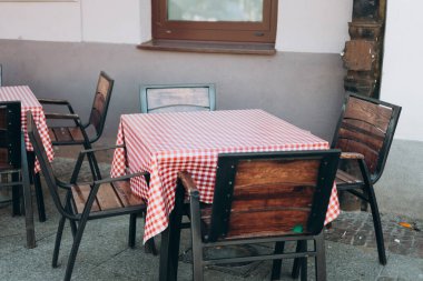 Açık sokak kafe masaları servis için hazır. Sabah vakti masa ve sandalyeli boş bir kafe terası. Yiyecek konsepti.