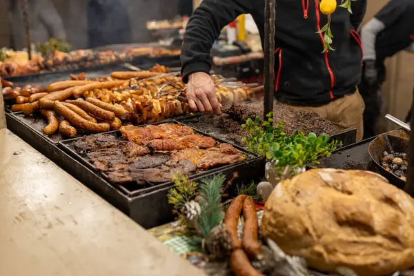 Polonya 'da bir ortaçağ fuarında sokak pazarında ızgara sosis. Sosis ve domuz eti yenmeye hazır. Sokak yemeği ve eti festivali. Noel Fuarı 'nda geleneksel sıcak yemek satmak..