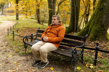 30 'lu yaşlarda genç bir adam sonbahar parkında bankta tek başına oturuyor. Yaşamı düşünüyorum. Doğada yalnız zaman geçirmek.