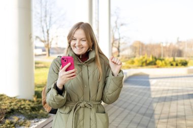 Gülümseyen kadın cep telefonu uygulaması kullanıyor, oyun oynuyor, online alışveriş yapıyor, internetten rezervasyon yapıyor. Piyangoda zaferi kutlayan mutlu kadın. Şaşırmış hipster online açık artırmada internet sitesinde bahisle kazandı.