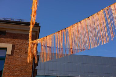 Birçok kırmızı kurdele şehir arka planında rüzgarda savruluyor. Ülkede festival var. Şenlik dekorasyonu konsepti. Yüksek kalite fotoğraf