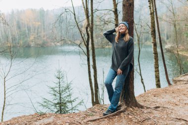 Sonbahar yürüyüşçüsü kadın kamp yapmak için doğa ormanına ve göle gidiyor. Görkemli gölün manzarası. Aktif yaşam tarzı. Seyahat konsepti. Yüksek kalite fotoğraf.