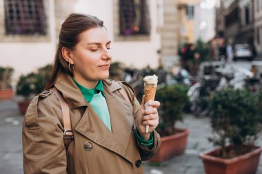 Lezzetli şam fıstıklı dondurma. Kapalı çekimde elinde taze waffle külahıyla pembe dondurma taşıyan bir kadın resmi var. Yaşam tarzı, seyahat, insan konsepti.