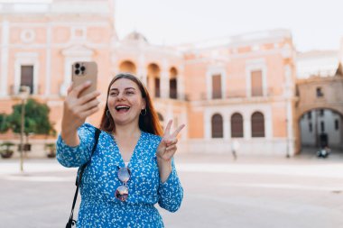 Mutlu 30 'lu yılların kadınları kentin arka planında selfie çekiyor. Valencia Katedrali 'ni ziyaret eden bir gezgin. İspanya 'da yaz tatilleri. Dişi, şehri keşfediyor. En iyi turistik yer..