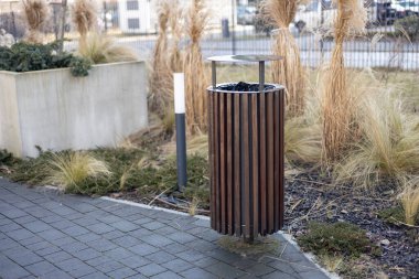 Wooden Public trash can on a city street filled with garbage