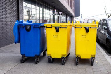 Plastik atık için sarı ve mavi geri dönüşüm kutusu. Polonya 'daki çöp ayrımı için çöp konteynırları. Çevresel koruma gezegeni kirlenmeden koruyor