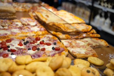 İtalya 'da bir restoranın vitrininde otantik İtalyan pizzası. Cam vitrinlerde çeşitli pizzacılar