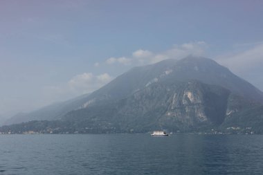 Como Gölü manzarası. Köy, ağaçlar ve dağlar.