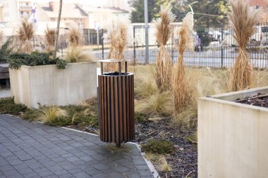 Wooden Public trash can on a city street filled with garbage