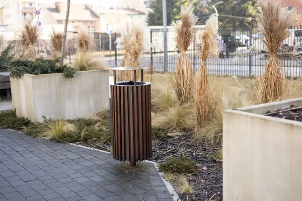 Wooden Public trash can on a city street filled with garbage