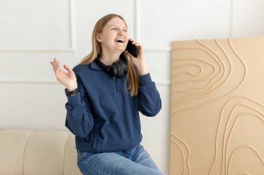 Mutlu, genç bir kadın evde telefonla konuşuyor, gülümsüyor 30 'lu yaşlarda bir kız cep telefonuyla telefonlara bakıyor, otobüsün üstünde oturuyor..