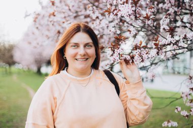 Kiraz çiçekli bir kadının portresi. Bedava açık hava eğlencesi, bahar çiçekli bahçe..