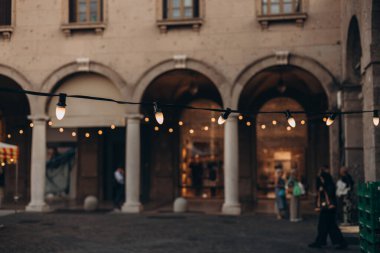 Dekoratif klasik sokak lambaları, beyaz tonlu. Açık Sokak Elektrik Çelengi. Eski ampuller. Telli ampuller. Partide Festoon sicim ışıkları süslemesi