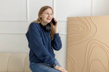 Mutlu kız konuşuyor, tartışıyor ya da evde sohbet ediyor, telefonda mutlu ve sosyal medya konuşuyor. Neşeli hayalperest kadın telefonda konuşuyor.