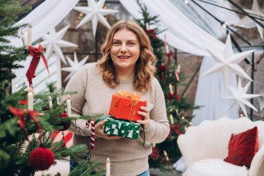 Mutlu Noeller, mutlu tatiller. Mutlu, genç bir bayan Noel hediyeleri alıyor..