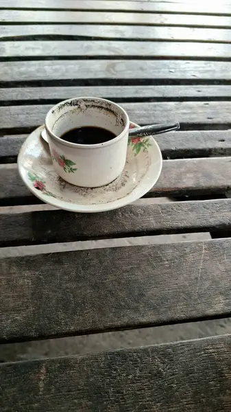 Klasik Endonezya Black Coffee in Vintage Floral Cup on Wooden Table Geleneksel Sert Bira with Sediment made from Coffee arabica or Coffee robusta for Daily Caffeine Ritual