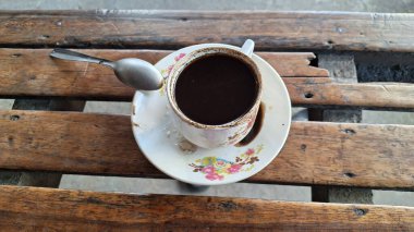 Benzersiz ve antika cam bir fincanda bol hamurlu koyu koyu bir kahve. 