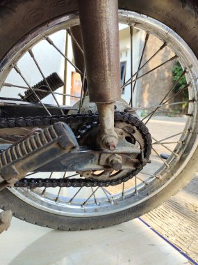 Zincirli eski motosiklet tekerleği. Motosiklet tekerleği yolda.