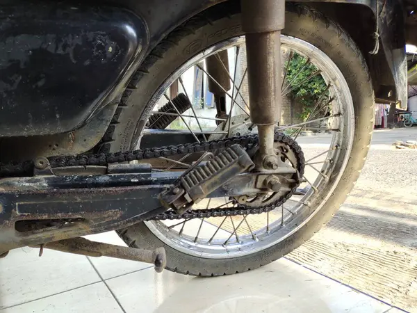 stock image old motorcycle wheel with chain. Motorcycle wheel on the road.