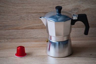Geyser kahve makinesi ve kahve makinesi için kırmızı kapsül tahta masanın üzerinde. Ekoloji ve atık geri dönüşümü kavramı.