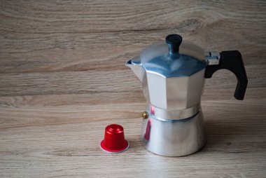 Geyser kahve makinesi ve kahve makinesi için kırmızı kapsül tahta masanın üzerinde. Ekoloji ve atık geri dönüşümü kavramı.