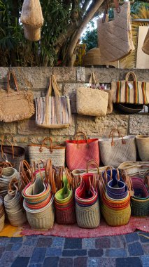 Le Lavandou, Cote dAzur, Fransa 'daki pazarda satılık renkli el yapımı saman çantaları ve sepetlerin sergilenmesi. Doğal malzeme, sürdürülebilir ürün.