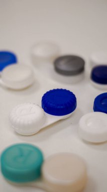 Farklı kontak lens kapları ya da kutular. Temizleme solüsyonu.