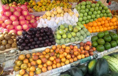 Goa, Hindistan - 13 Kasım 2018: çeşitli yerel meyveler satan bir yol kenarı meyve tezgahı. Avokado, karpuz, erik, kivi, tutku meyvesi, incir, Cherimoya.
